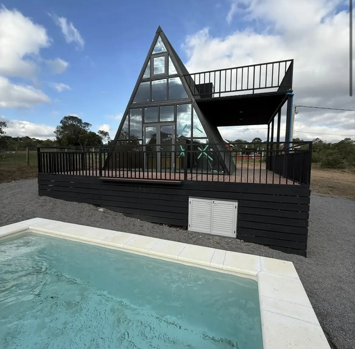 Casa estilo A-frame con terraza elevada y piscina