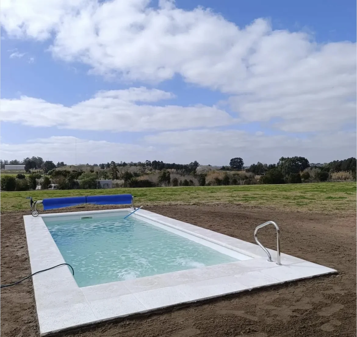 Piscina en terreno natural con cielo abierto y escalera metálica