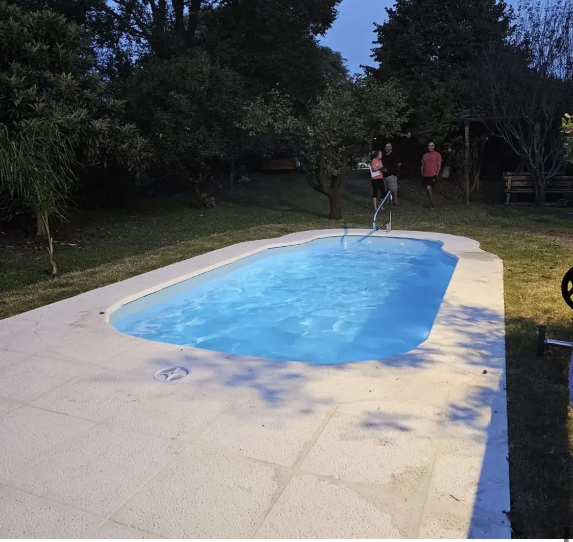 Piscina residencial terminada, con agua azul y jardín